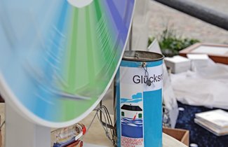 Auf dem Messestand des Vereins zur Förderung des Flensburger Schifffahrtsmuseums e.V. steht ein Glücksrad. Dieses wurde gerade gedreht, sodass sich die Farben der einzelnen Gewinn- und Nietenfelder nahezu mischen.