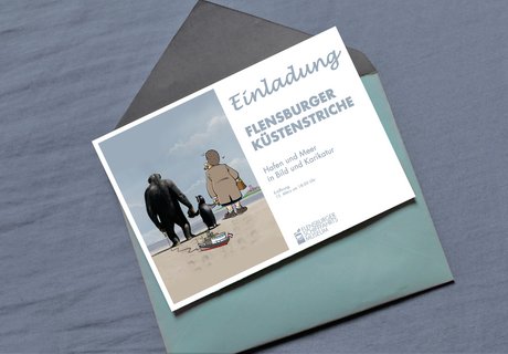 Auf dem Foto ist ein blauer Briefumschlag zu sehen. Dieser ist geöffnet. Auf dem Briefumschlag liegt eine Einladungskarte zur Eröffnung der Sonderausstellung FLENSBURGER KÜSTENSTRICHE im Flensburger Schifffahrtsmuseum.