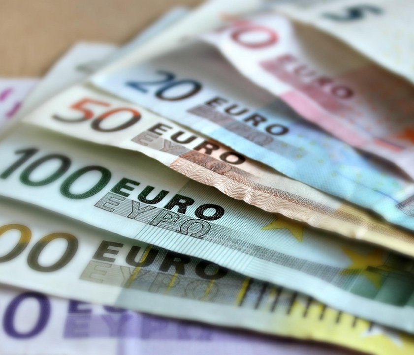 Auf dem Bild sind verschiedenen Geldscheine zu sehen. Sie liegen aufgefächert auf einem Tisch.