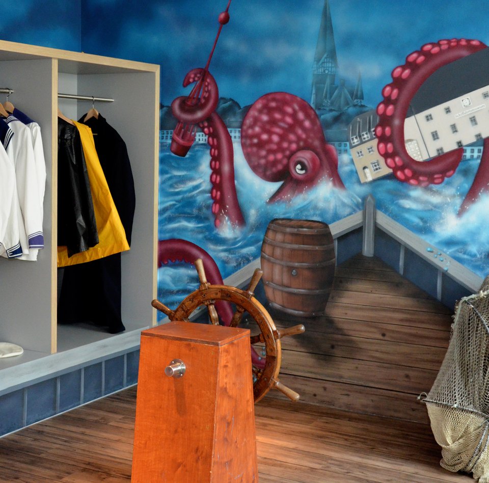 Im Flensburger Schifffahrtsmuseum kann man sich verkleiden und vor einer Wand fotografieren. Auf der Wand ist ein Bild von einem Riesenkraken gesprüht, der das Gebäude des Schifffahrtsmuseums mit seinem Tentakel festhält. Das Graffiti deutet an, dass man sich auf einem Schiff befindet und direkt auf den Riesenkraken zusteuert.